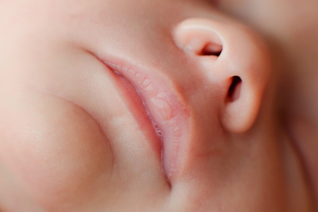 Caucasian Newborn baby face closeup macro detail shot. child portrait, health skin, tenderness
